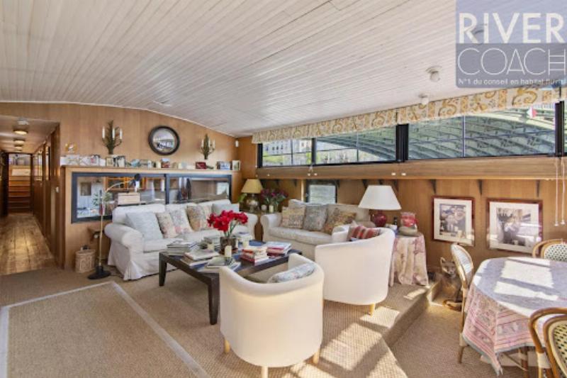 Une vue emblématique de Notre-Dame de Paris depuis les quais de Seine, avec un nouvel hôtel parisien de caractère en arrière-plan et des péniches.